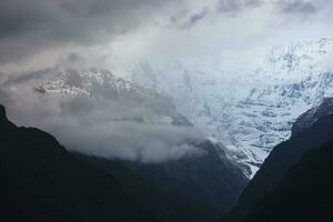 stormig moln över de bergen av de annapurna räckvidd på de annapurna bas läger spår i de nepal himalaya. foto