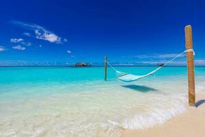 tropisk strand bakgrund som sommar natur landskap med strand gunga eller hängmatta och vit sand och lugna hav för strand baner. perfekt strand scen semester och sommar Semester begrepp. foto