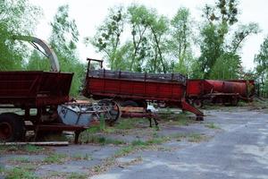 gamla traktorer och annat lantbruksmaterial på en skrotgård foto