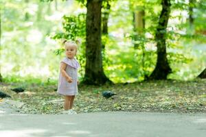 en Lycklig liten flicka av slavic utseende promenader i de parkera i de sommarplats för text foto