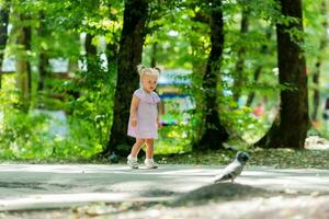 en Lycklig liten flicka av slavic utseende promenader i de parkera i de sommarplats för text foto