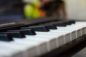 närbild av piano nycklar. piano svart och vit nycklar och piano tangentbord musikalisk instrument placerad på de Hem balkong under solig dag. foto