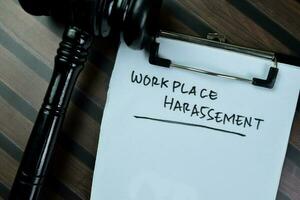 begrepp av arbetsplats trakasserier skriva på pappersarbete isolerat på trä- tabell. foto