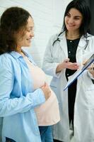 kontrollera ultraljud i 2:a graviditet trimester av gravid kvinna under ett förlossningsläkare utnämning i moderskap klinik foto