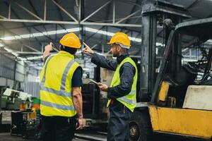 två underhåll ingenjörer inspektera systemet med dator. de arbete industri fabrik foto