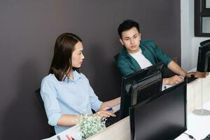 Foto av två ung asiatisk företag person arbetssätt på kontor