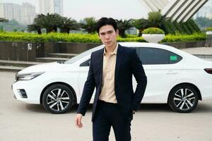 ung asiatisk företag man med bil foto