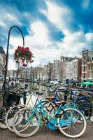Cyklar, kanaler, blommor och arkitektur på de gammal central distrikt av amsterdam foto