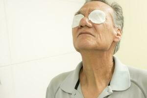 senior man i de badrum använder sig av bomull dynor för öga lättnad foto