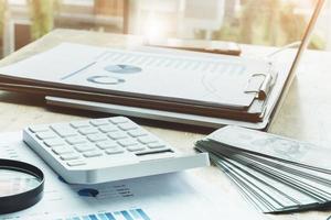verktyg affärsfinansiell med fokus vit kalkylator med budget och finansiellt dokumentpapper på trä skrivbord i kontorsrum foto