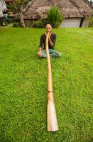 man med en bambu instrument foto