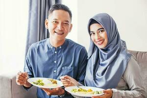 skön sydöst asiatisk par äter tillsammans fira eid al fitr eller eid al Adha foto