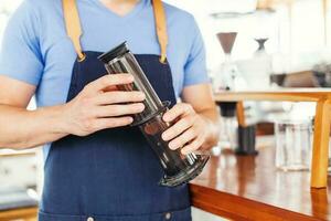 Icke traditionell kaffe bryggning. händer innehav aeropress foto