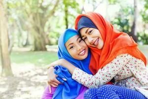 två förtjusande indonesiska muslim systrar foto