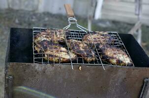 grillad fläsk på de grill. fräsning kött på de grill. kött i ett järn maska. foto