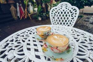 en uppsättning av årgång tvilling varm kaffe latte på de tabell. foto