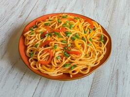 spaghetti med grönsaker på en tallrik foto