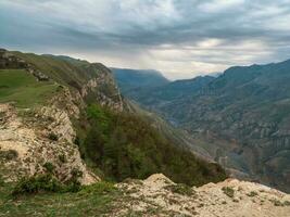 färgrik regnig landskap med klippa och stor klippig bergen och episk djup klyfta. hög sten toppar av dagestan berg. foto