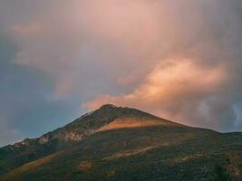 bergen på gryning. atmosfärisk landskap med silhuetter av bergen på bakgrund av rosa gryning himmel. färgrik natur landskap med solnedgång eller soluppgång. solnedgång i urblekt toner. foto