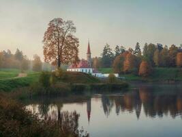 solig höst morgon- landskap. en ljus höst dimmig landskap med gyllene träd förbi de damm och ett gammal palats. gatchina. Ryssland. foto