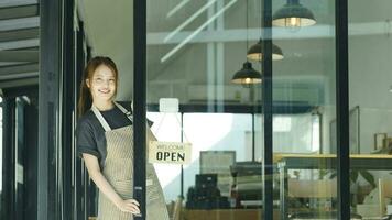 ung företag ägare öppen de kaffe affär. foto