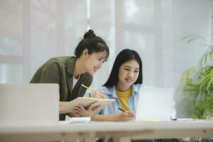 ung asiatisk universitet studenter studerar inlärning diskutera arbetssätt på dator. foto