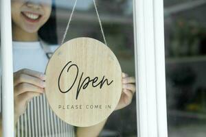 stänga upp ung asiatisk företag ägare öppen de kaffe affär. foto