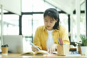 allvarlig ung asiatisk studerande läsning en bok framställning de examen. foto