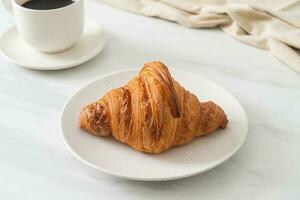 färsk croissant på vit platta foto