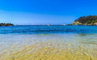 strand sand blå turkos vatten vågor stenar panorama puerto escondido. foto