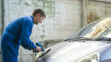 caucasian man är använder sig av bil putsning maskin i reparera mekaniker målning affär foto