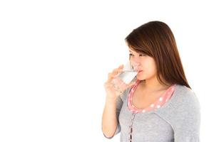 frisk asiatisk kvinna dricker vatten på vit bakgrund foto