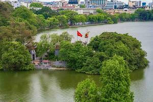 hanoi, viet nam - 13 Maj 2023 antenn se av hoan kiem sjö ho guom eller svärd sjö i de Centrum av hanoi i de dimma i de morgon. hoan kiem sjö är en känd turist plats i hanoi. resa begrepp foto