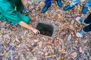 de cu chi tunnlar. en guide demonstrera på vilket sätt en vietcong Dölj in i de tunnel. dess Begagnade i vietnam krig. känd turist attraktion i vietnam. stock Foto