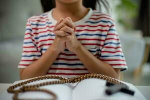 kristen begrepp. liten asiatisk flicka bön- kvarhållning de korsa. begrepp av hoppas, tro, kristendom, religion, foto
