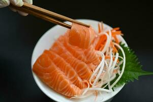 färsk rå lax fisk för matlagning mat skaldjur lax fisk, lax sashimi mat lax filea japansk meny med shiso perilla blad citron- ört och kryddor foto