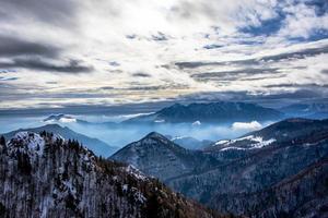 snötäckta alpina toppar i molnen två