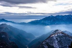 snötäckta alpina toppar i molnen tre foto