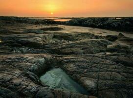 dramatisk molnig solnedgång landskap av klippig på vild atlanten sätt, tång strand i grevskap galway, irland foto