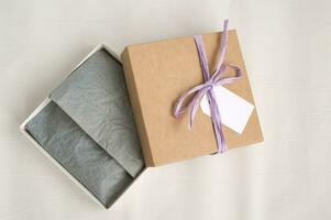 öppen brun gåva fyrkant hantverk låda med band, attrapp märka, pris märka. papper för förpackning kläder foto