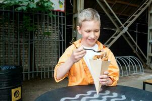 söt pojke äter ljuv hong kong våffla i en gata Kafé, gata mat foto