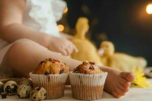 söt fluffig ankungar på de påsk tabell med vaktel ägg och påsk cupcakes, Nästa till en liten flicka. de begrepp av en Lycklig påsk foto