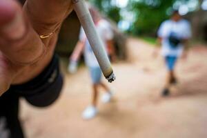 närbild manlig hand som håller en cigarett. foto