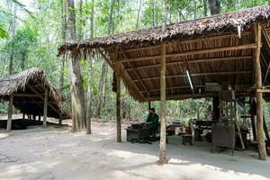 de cu chi tunnlar. en guide demonstrera på vilket sätt en vietcong Dölj in i de tunnel. dess Begagnade i vietnam krig. känd turist attraktion i vietnam. stock Foto