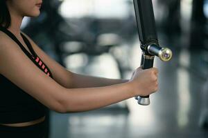 asiatisk sport kvinnor övning vikt Träning och träna hantel maskin Träning på de Gym. idrottare flicka Träning stark och Bra hälsa och styrka foto
