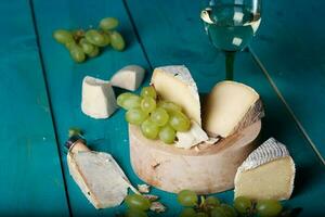 ost, vindruvor och vin på trä- cyan yta. foto