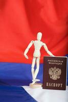 ryska passera och trä- dummy statyett på ryska flagga. foto
