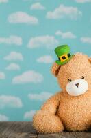 brun plysch teddy Björn i en pyssling hatt på en trä- yta. foto