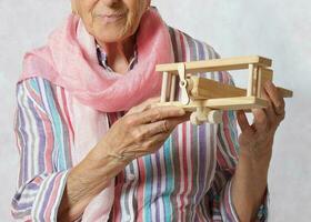 gammal kvinna och trä- tillverkad flygplan. foto