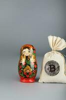 ryska trä- docka -matryoshka och säck av bitcoins. foto